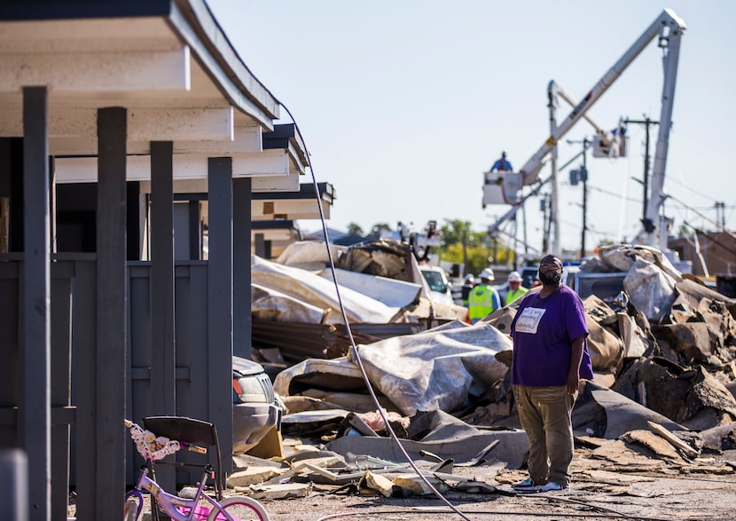 Alvin Dunbar walks near a carport outside of his tornado-damaged apartment on Wednesday,...