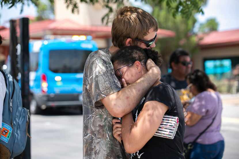 Kianna Long and husband Kendall Long embrace near the Walmart where a man opened fire on...