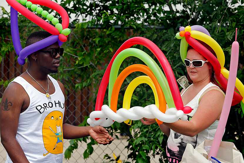 Dominique Miles (left) of Lewisville assisted balloon artist Shanda Jarrell of Carrollton as...