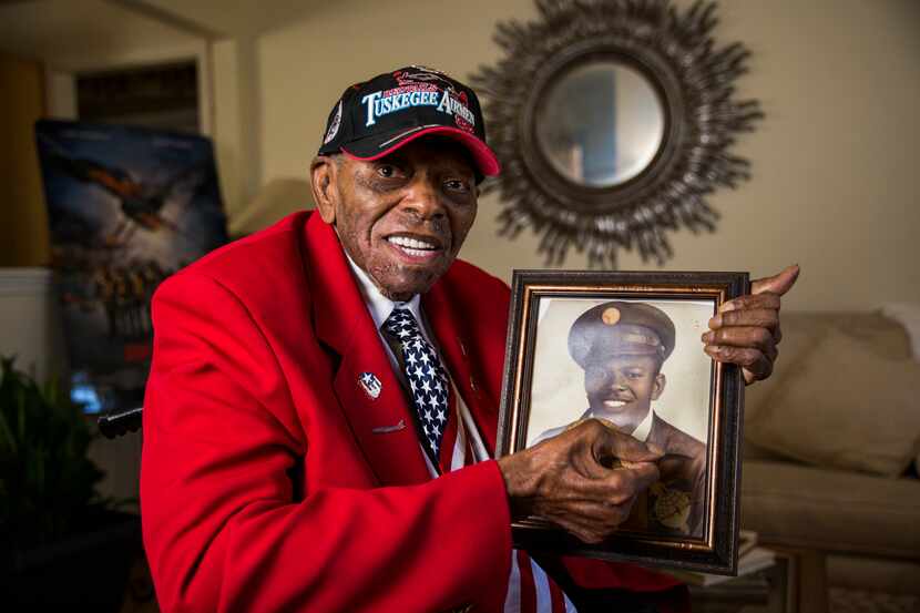 Staff Sgt. Homer Hogues, a retired Tuskegee Airman, holds a portrait of himself in 2015 at...