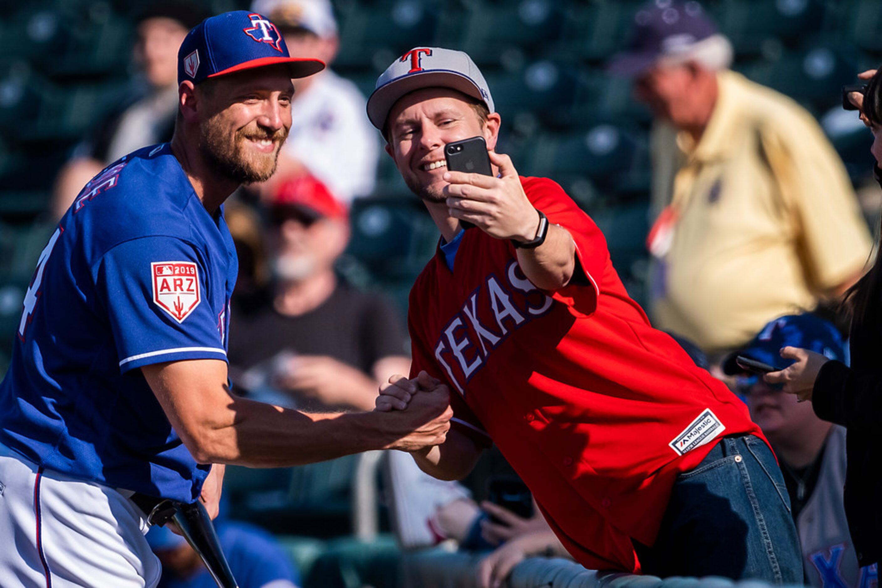 Texas Rangers outfielder Hunter Pence poses for a selfie with a fan as he heads back to the...