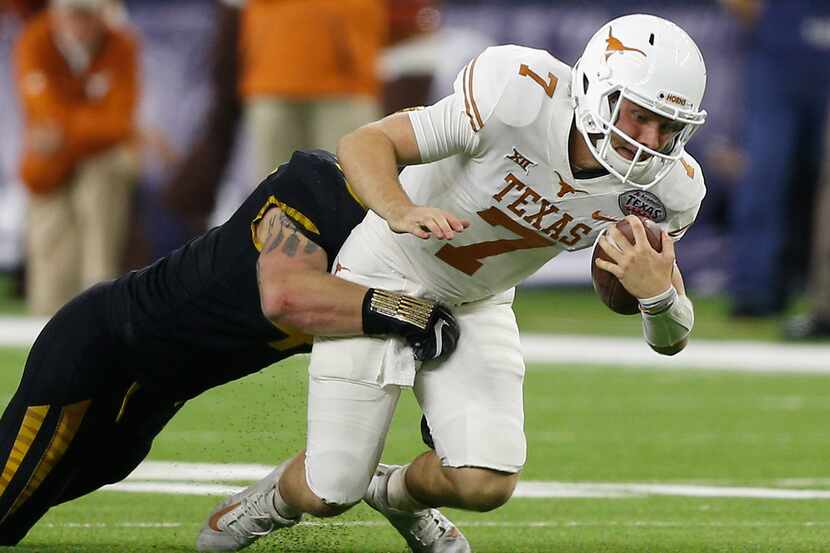 HOUSTON, TX - DECEMBER 27:  Shane Buechele #7 of the Texas Longhorns is sacked from behind...