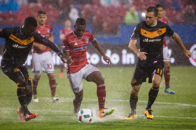 FC Dallas forward Fabian Castillo (11) controls the ball ahead of Houston Dynamo defender...