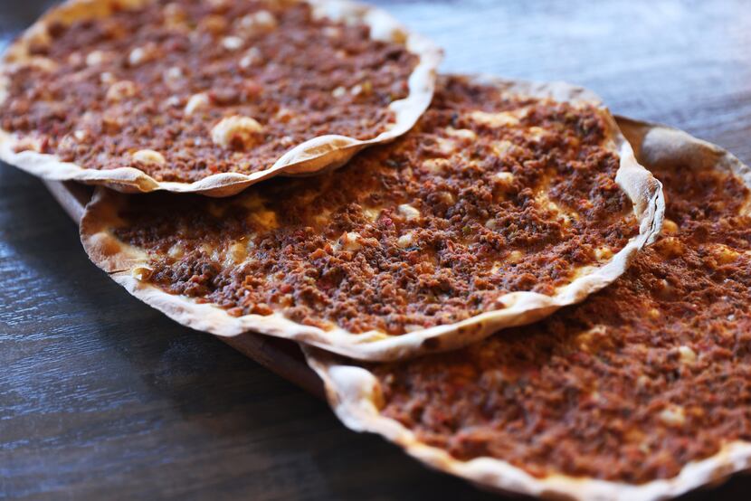 Lahmacuns have a very thin crust and are topped with a mixture of minced beef, tomatoes,...