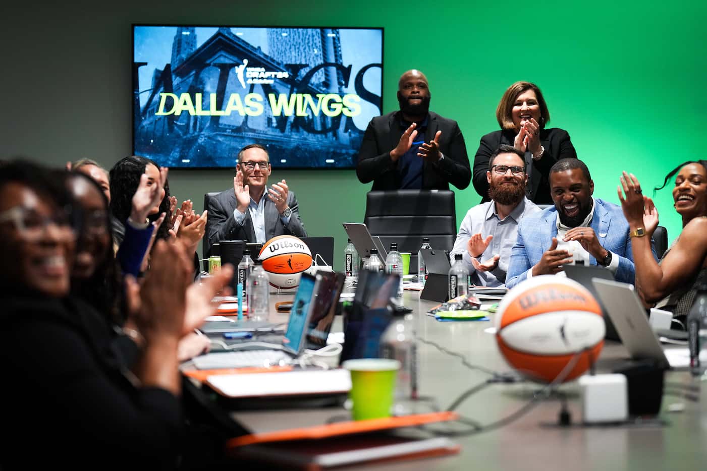 Dallas Wings President and CEO Greg Bibb (seated, facing), assistant general manager Travis...