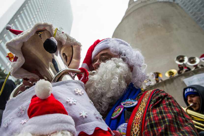 Warren Brooks, who is dressed as Santa Claus, performs with over 250 other tuba, sousaphone...