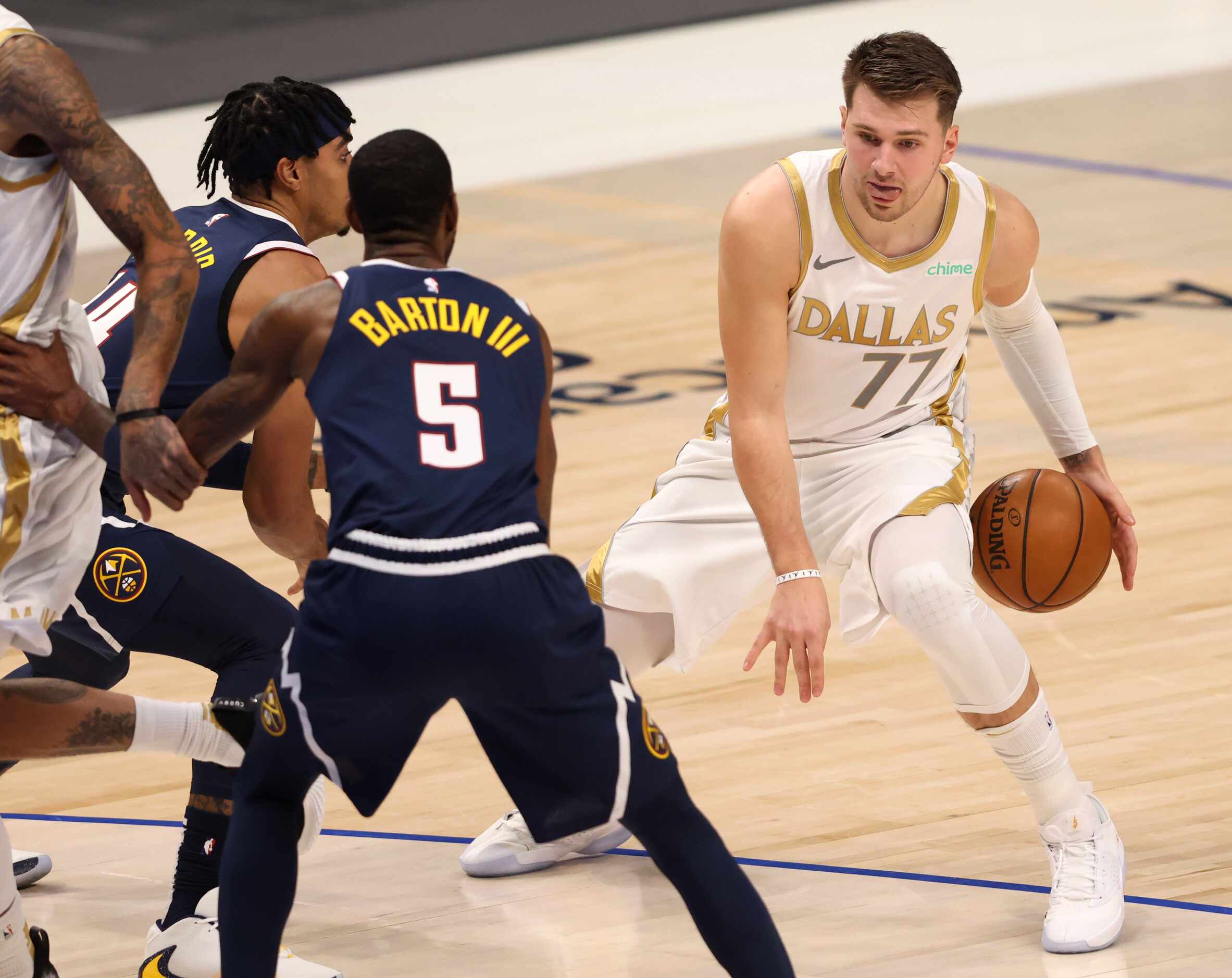 Dallas Mavericks guard Luka Doncic (77) dribbles between his legs in front of Denver Nuggets...