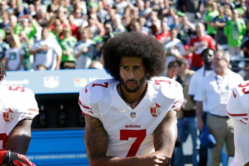 Former San Francisco 49ers quarterback Colin Kaepernick kneels during the national anthem in...