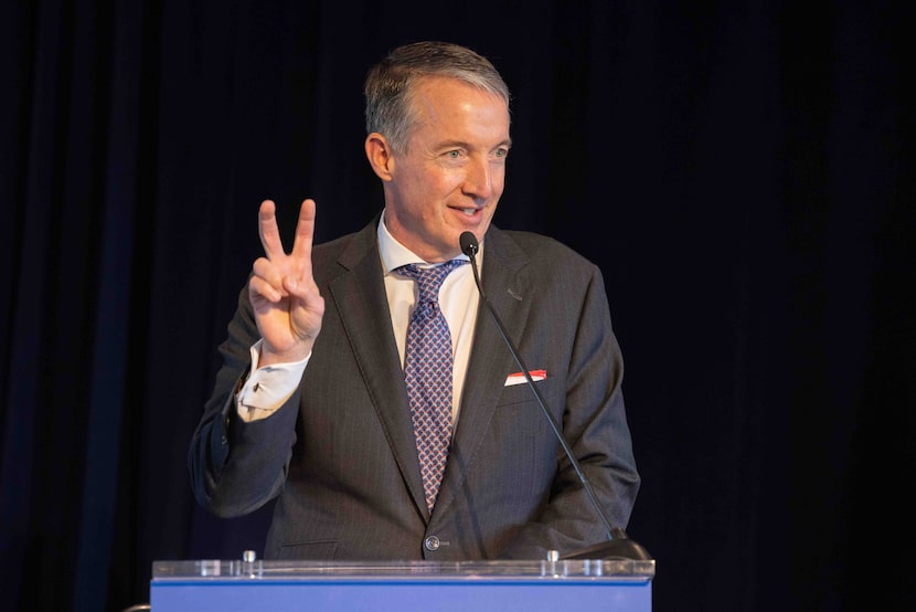 University of Texas President Jay Hartzell does the SMU “Pony up” hand sign during a press...