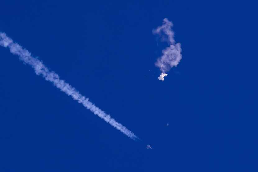 The remnants of a suspected Chinese spy balloon drift above the Atlantic Ocean, just off the...