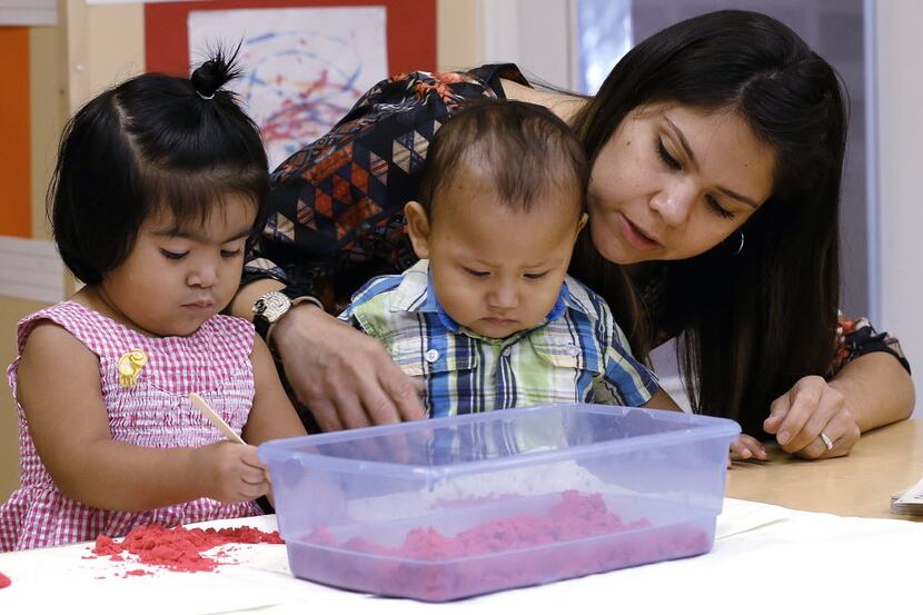 Elizabeth Mancilla, right, one of the teachers at the Child Care Group helps Andrea Ramirez,...