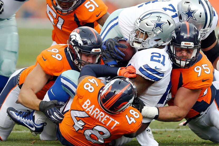 Dallas Cowboys running back Ezekiel Elliott (21) is stopped by Denver Broncos defensive...