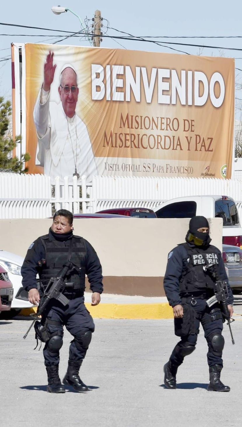 
Federal police patrol near a banner welcoming Pope Francis’ “mission of mercy and peace” at...