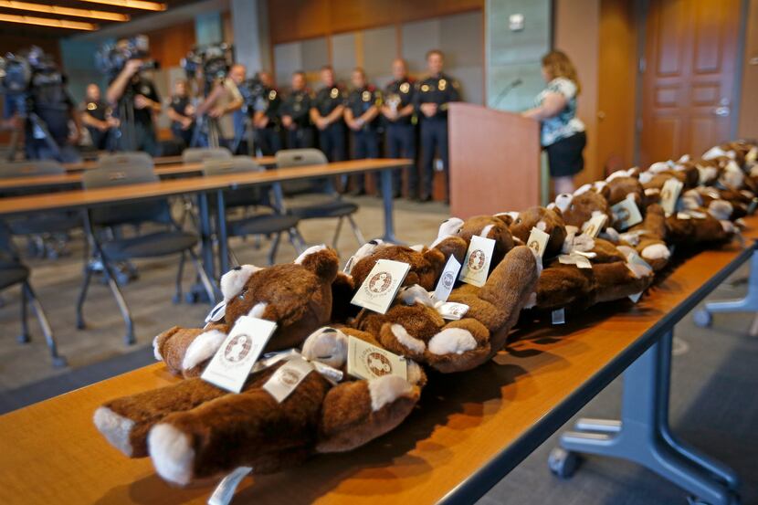 Teddy bears sit on the table during a press conference at Grand Prairie Police Department in...