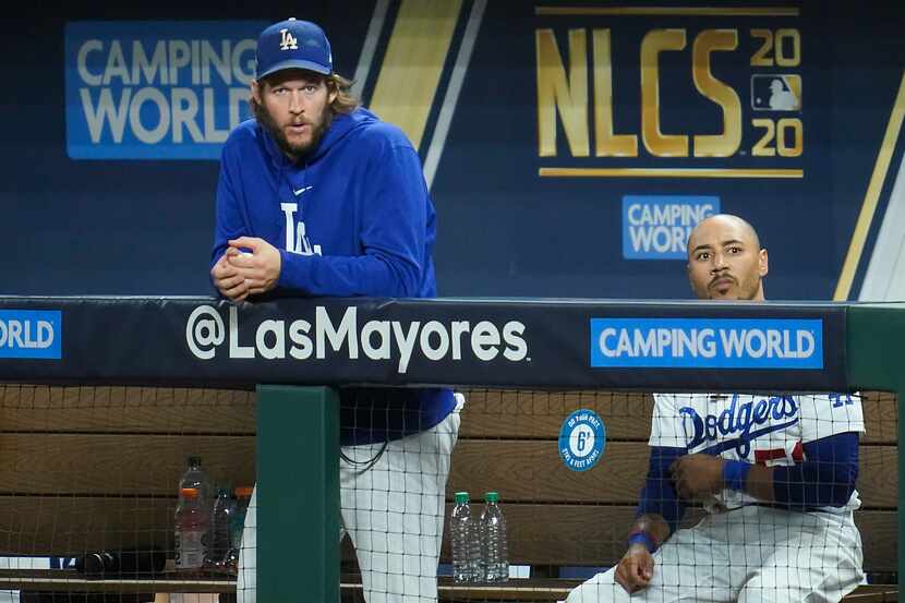 Los Angeles Dodgers starting pitcher Clayton Kershaw (left) watches from the dugout with...