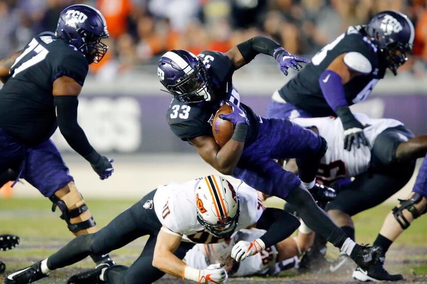 TCU Horned Frogs running back Sewo Olonilua (33) has his feet taken out from under him by...