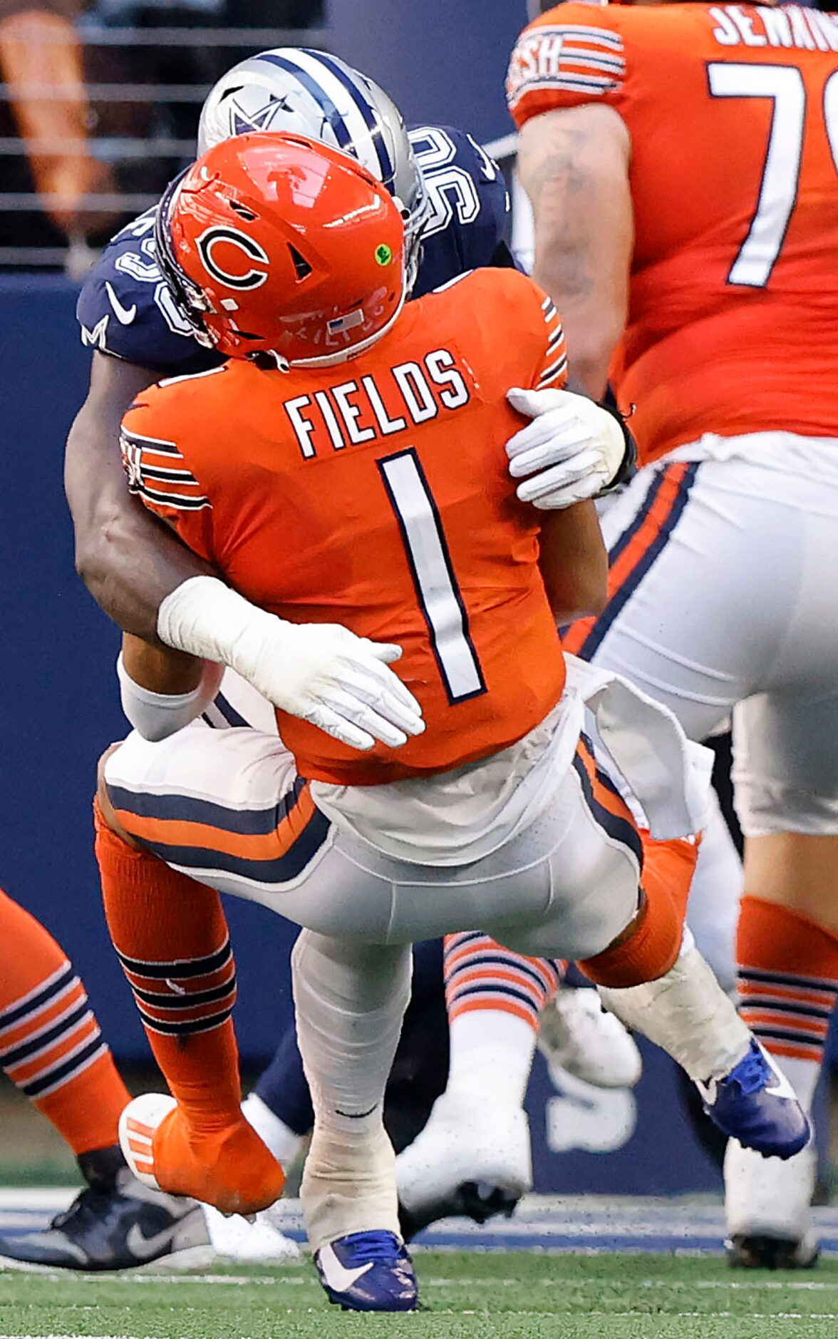 Dallas Cowboys defensive end DeMarcus Lawrence (90) bear hugs Chicago Bears quarterback...