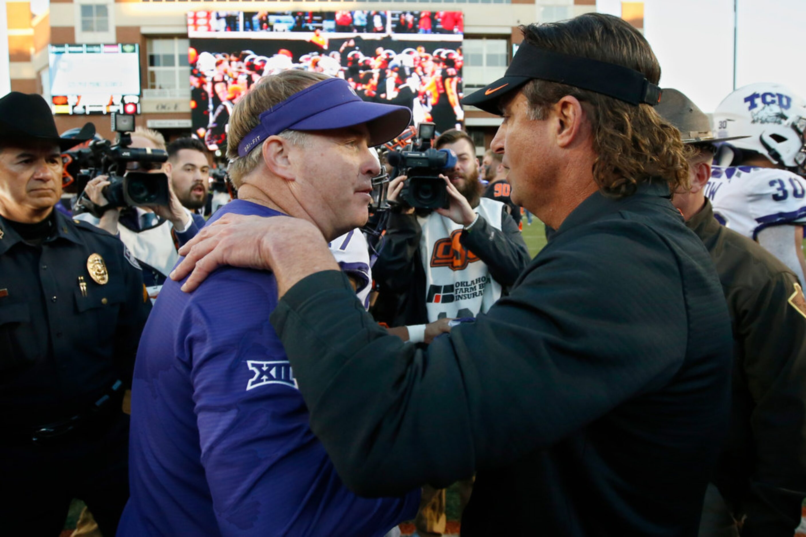 TCU head coach Gary Patterson, left, and Oklahoma State head coach Mike Gundy, right, talk...