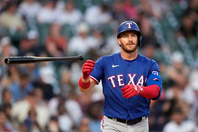 Texas Rangers designated hitter Robbie Grossman flips his bat after a base on balls during...