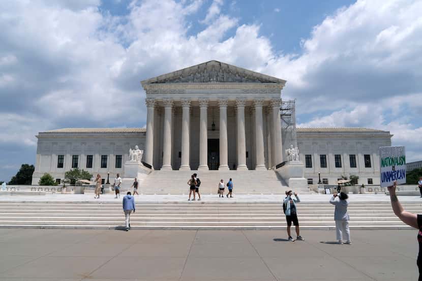 Visitors pose for photographs outside the U.S. Supreme Court, Tuesday, June 18, 2024, in...