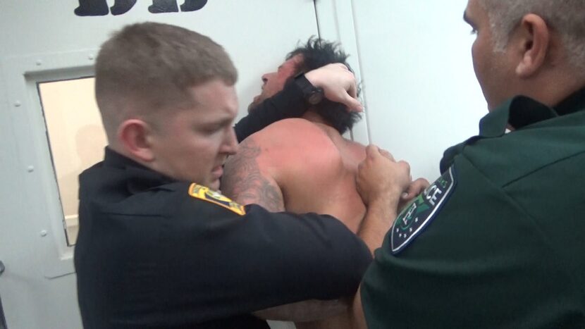 Jail staff and a local police officer restrain Andy DeBusk in 2016 while he was held inside...