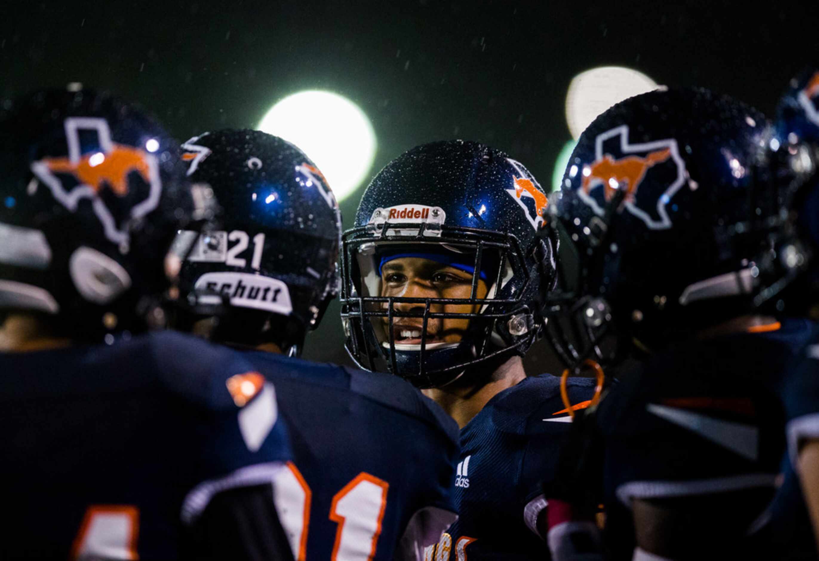 Sachse players stand on the sideline in the rain during the third quarter of a District...