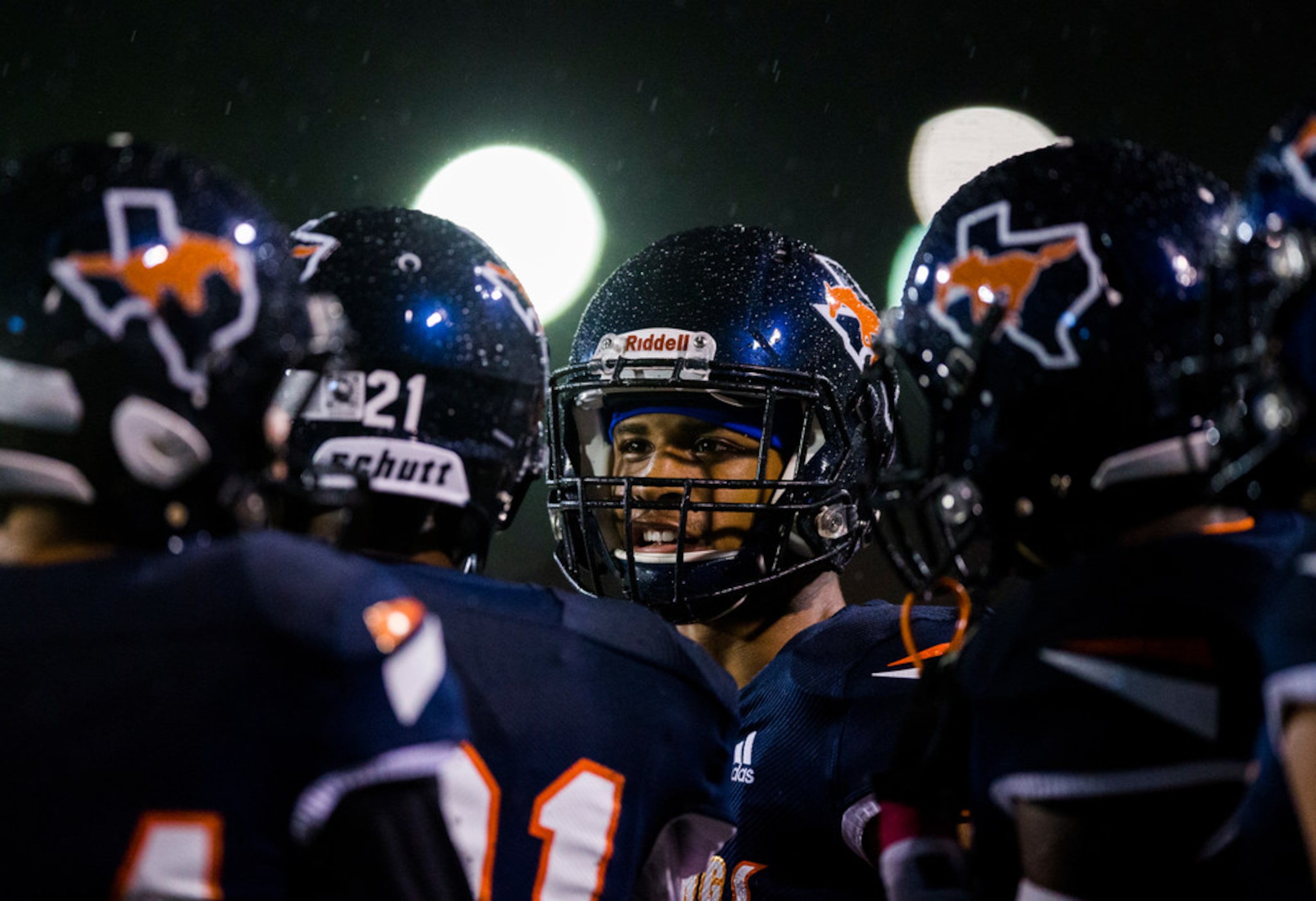 Sachse players stand on the sideline in the rain during the third quarter of a District...