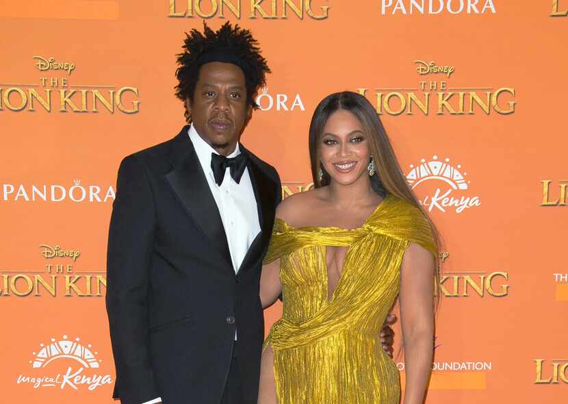 Jay-Z, left, and Beyonce pose for photographers upon arrival at the "Lion King" premiere in...