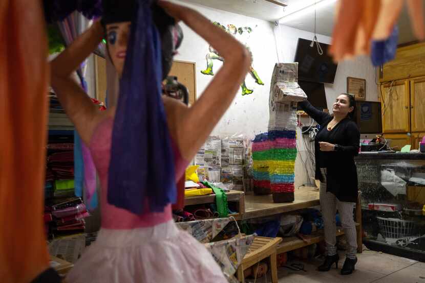 Veronica Diaz, owner and piñata maker of Piñatas Daphne, adds finishing touches to a donkey...