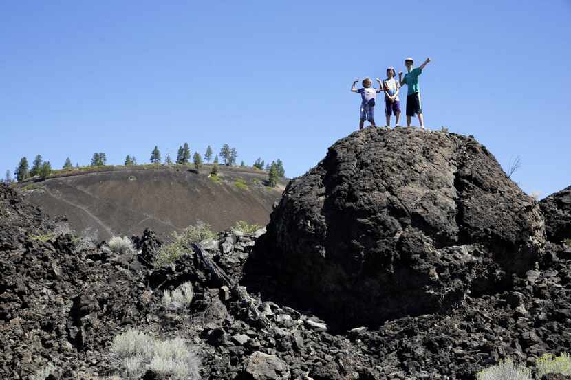 Visitors climb the natural formations at the Newberry National Volcanic Monument in...