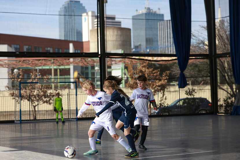 Kids from Alpha Forms Academy and the Eastside Mustangs competed in a soccer game on one of...