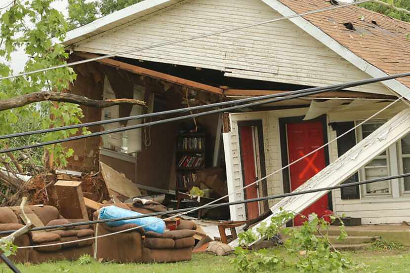 An X on the door of a tornado-damaged home along East Pennsylvania Street in Van, Texas,...