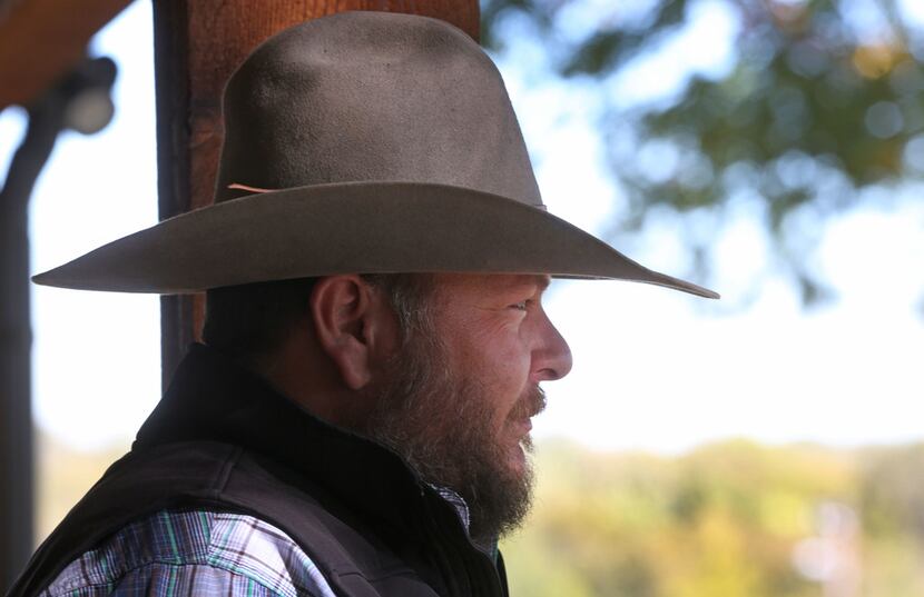Cade Nichols of A Bar N Ranch stands on the porch at the ranch in Sherman.