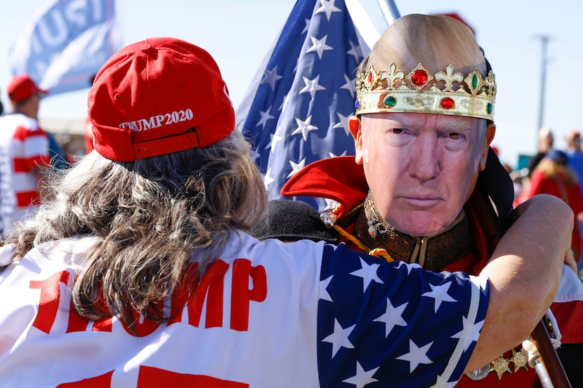 Brian Winn of Houston, wearing a Trump mask, hugs Trisha Hope outside of Waco Regional...