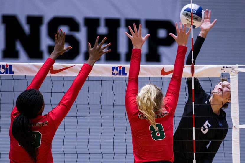 Hebron's Nicole Drewnick (5) spikes the ball past The Woodlands' Amanda Ifeanyi (10) and...