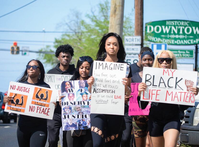Shannon Williams (center) and Lindsey Ogbonna (right) march with other Stephen F. Austin...