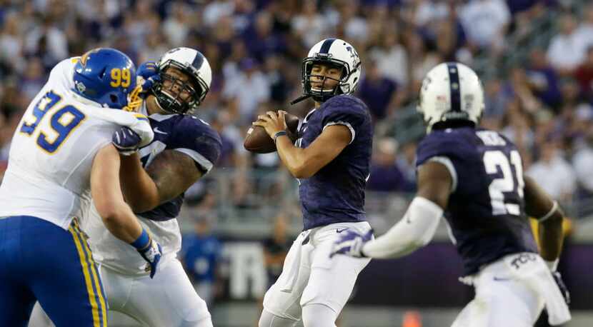 TCU quarterback Kenny Hill (7) looks to pass to running back Kyle Hicks (21) as offensive...