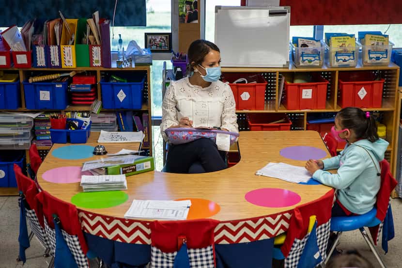 Kindergarten teacher Michelle Davis administers a quick literacy diagnostic test to Briana...