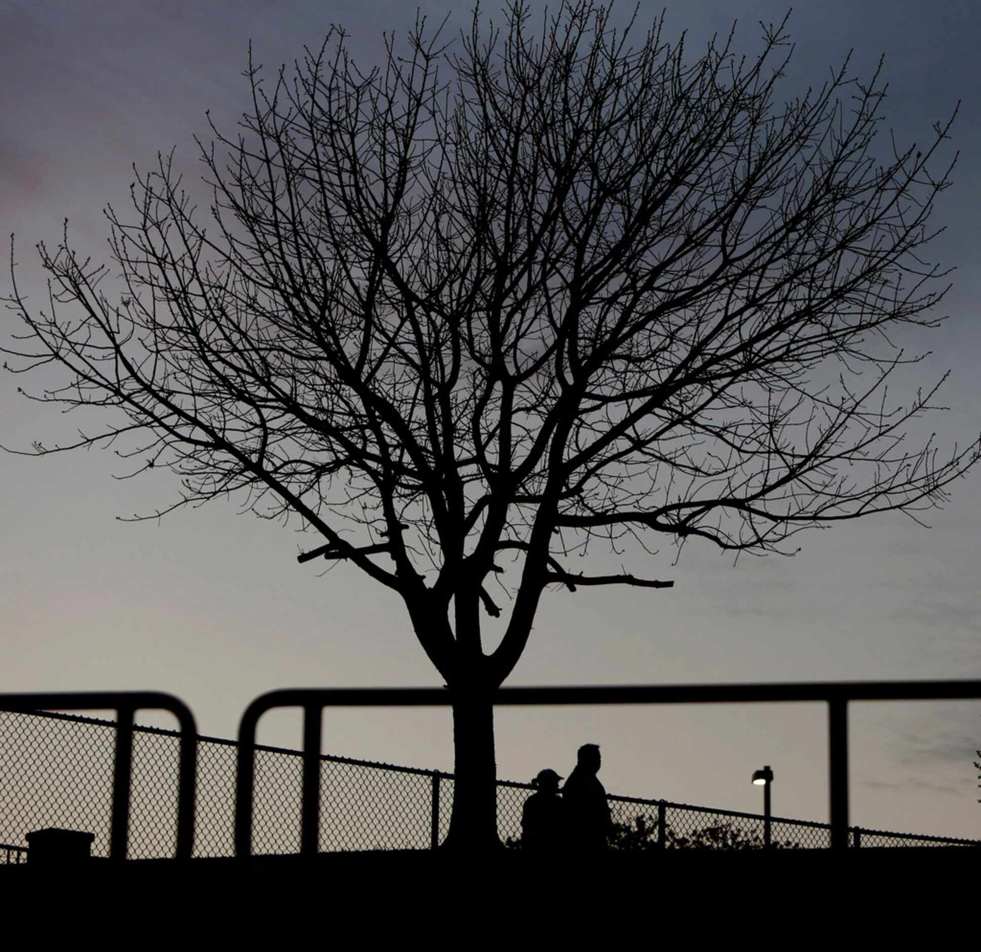 A couple of soccer fans make their way to their seats as the sun sets just prior to the...