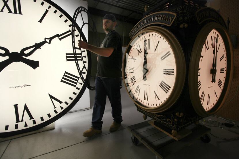 Dan LaMoore of Electric Time Company moves a clock face at their plant in Medfield, Mass.,...
