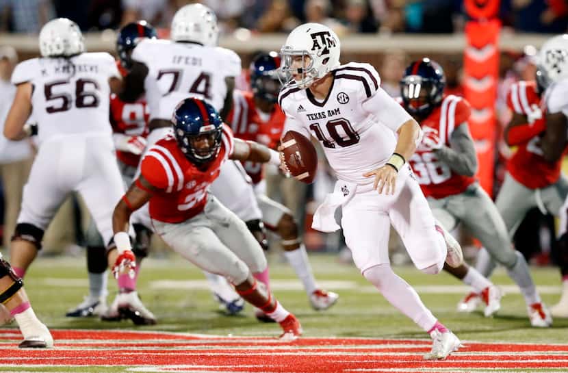 Texas A&M quarterback Kyle Allen (10) scrambles for a short gain while being pursued by...
