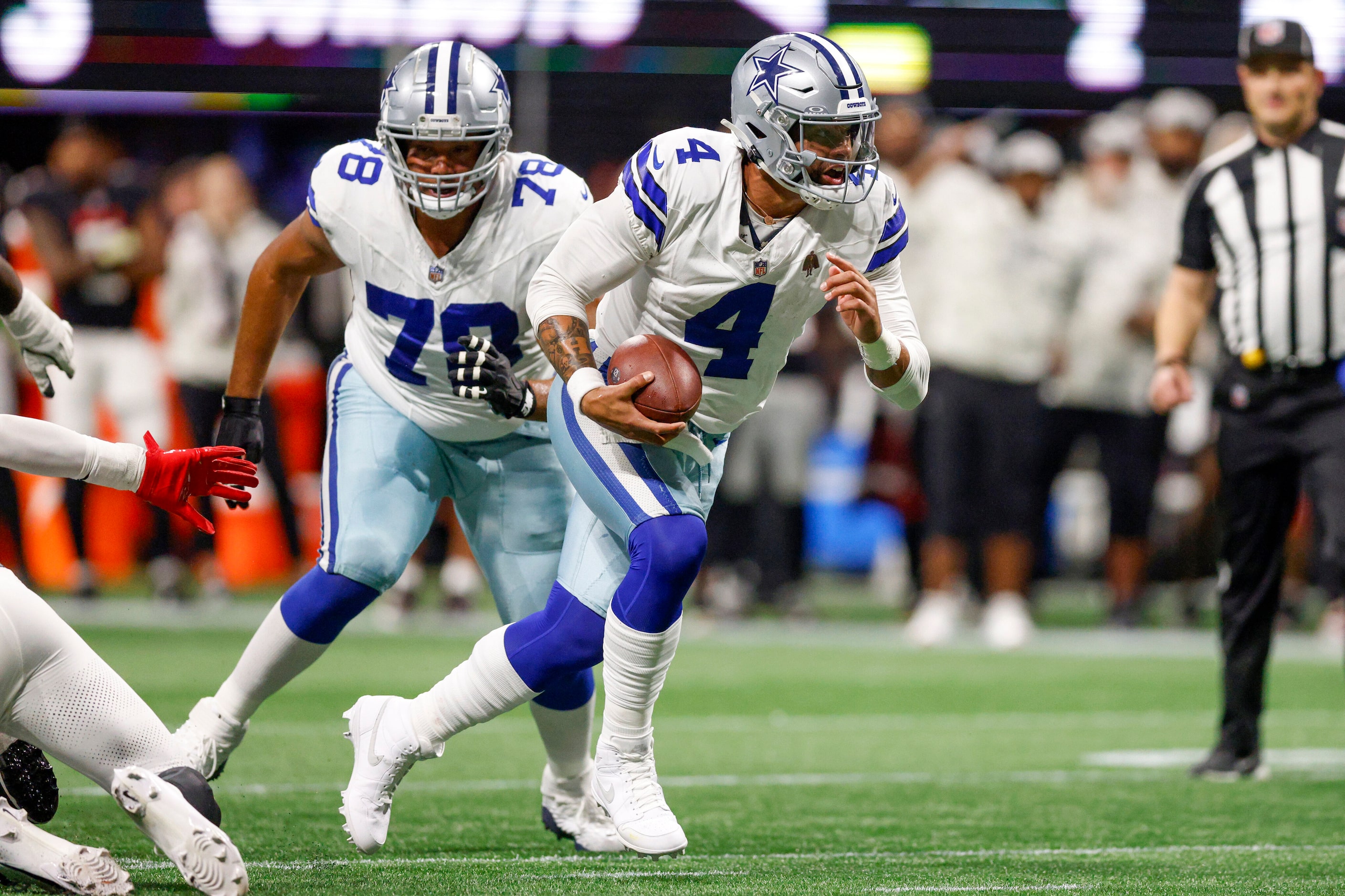 Dallas Cowboys quarterback Dak Prescott (4) scrambles out of the pocket as he looks...