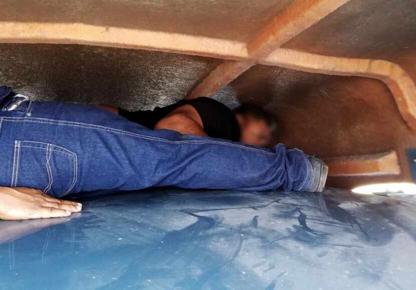 Two of the illegal immigrants found by border agents hidden in the windjammer of a tractor...