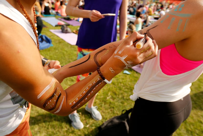 Yoga enthusiasts draw tribal markers on their bodies.