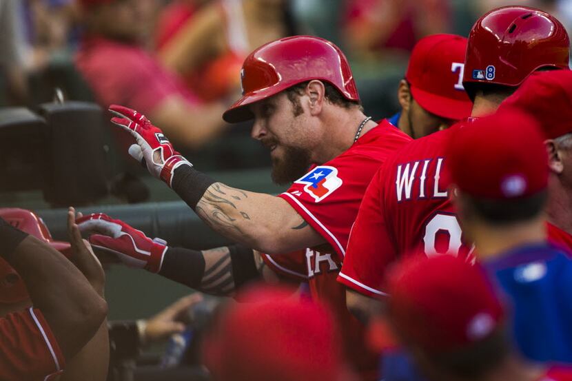 Texas Rangers left fielder Josh Hamilton (32) gets high-fives from team mates in the dugout...