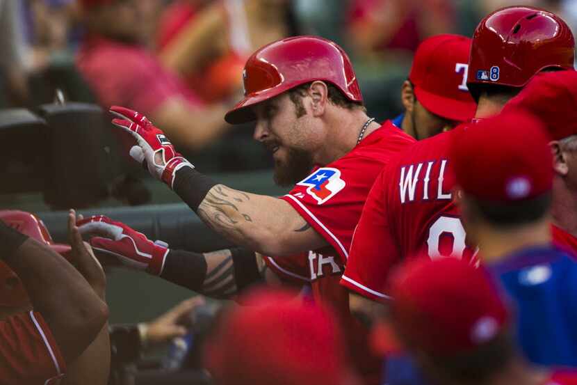 Texas Rangers left fielder Josh Hamilton (32) gets high-fives from team mates in the dugout...