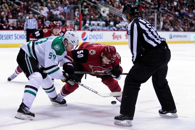 Feb 18, 2016; Glendale, AZ, USA; NHL linesman Shandor Alphonso (52) drops the puck for...