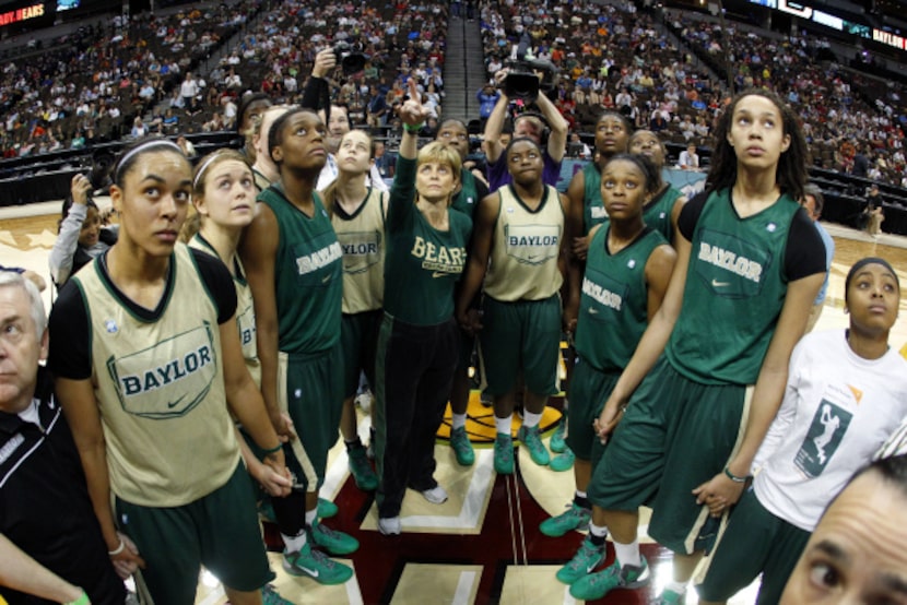 Baylor Bears head coach Kim Mulkey, center, points out the banner hanging in the rafters...