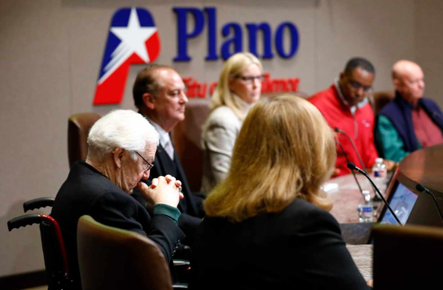 Plano city council member Tom Harrison (left) listens as fellow council call for his...