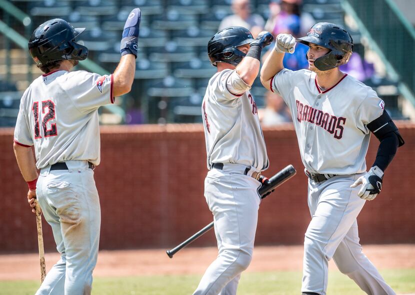 Hickory Crawdad's Justin Foscue (20), right, gets high fives from teammates Josh H. Smith...